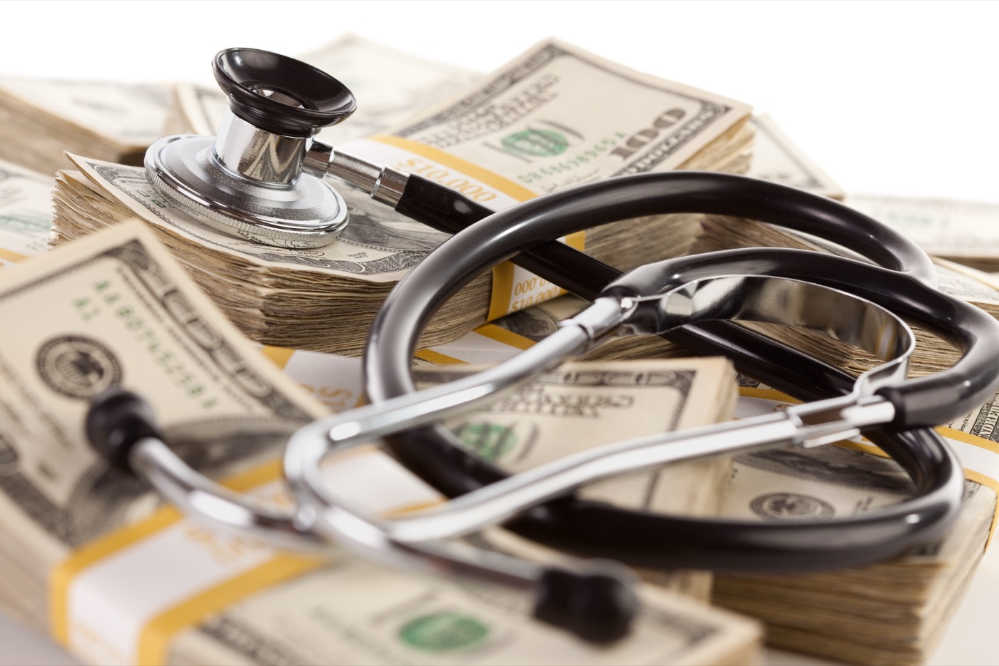 Stethoscope resting on stacks of cash